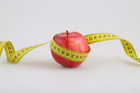 白色背景上的测量米的红苹果图片