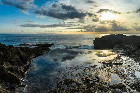 在海边的岩石。反映在池，秀美的海边的夕阳的天空