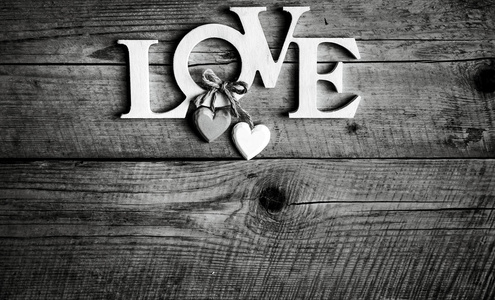 木制字母形成两个字写在木制背景上的爱。情人节那天。两颗心