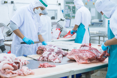 切割肉类屠宰工人在工厂里照片