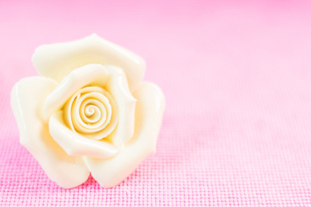 淡粉色的织物背景上的玫瑰 陶瓷