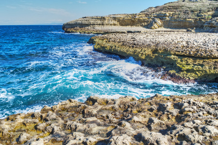 多岩石的海岸和在撒丁岛的蓝色水