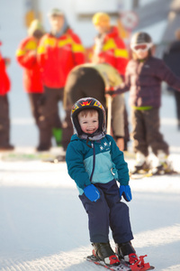 蹒跚学步的男孩在山上滑雪