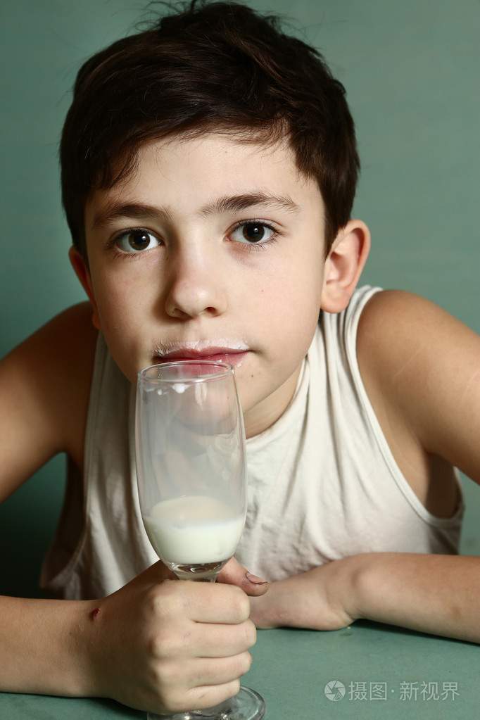 青春期前的英俊男孩喝牛奶