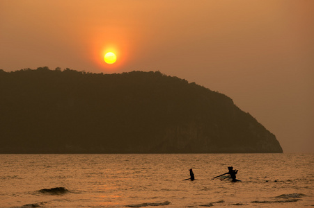 渔民与日落背景中的剪影