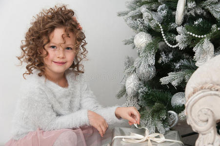 圣诞树附近带礼物的女孩