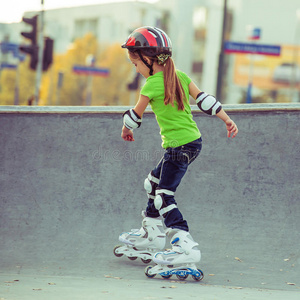 戴头盔的女孩在公园里溜冰