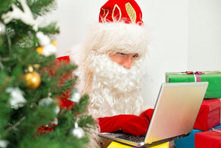 圣诞老人在用笔记本电脑。