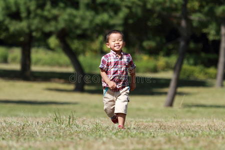 在草地上奔跑的日本男孩