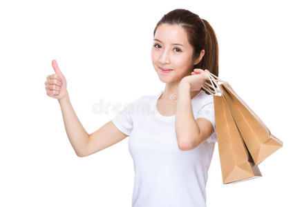 亚洲女人拿着购物袋，手指向上