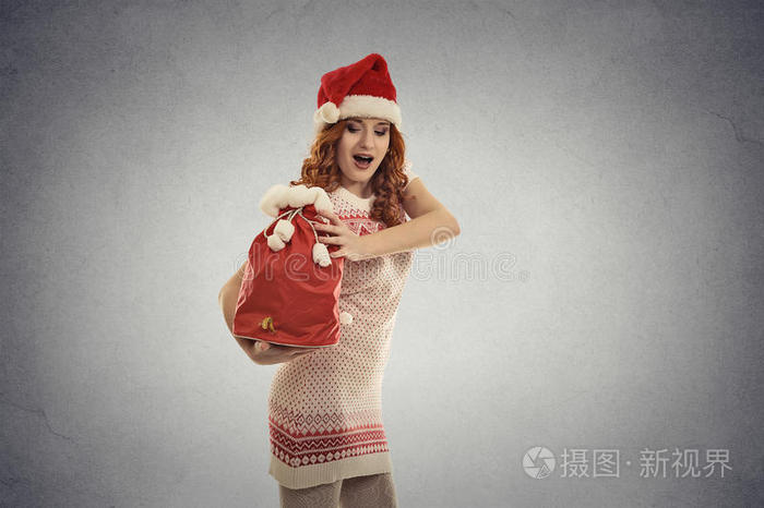 圣诞女帮手提着装满礼物的红色圣诞大袋子