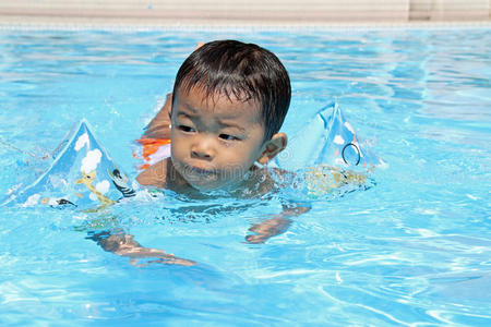 在游泳池里游泳的日本男孩