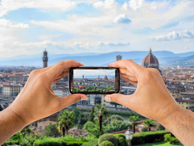 游客在佛罗伦萨举着照相机有智能手机的青少年快乐的跨国女孩们好奇地