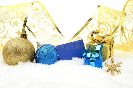 雪地上的金色和蓝色圣诞装饰和祝福卡