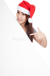 戴着红色圣诞帽的亚洲女孩指着倾斜的空白标志
