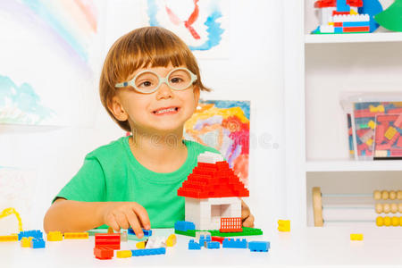 聪明的小男孩建造玩具塑料积木屋