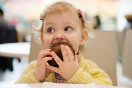可爱的女孩在咖啡馆吃松饼