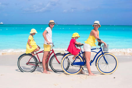 一家四口在热带骑自行车的年轻家庭