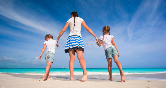 孩子们和快乐的母亲在海滩度假
