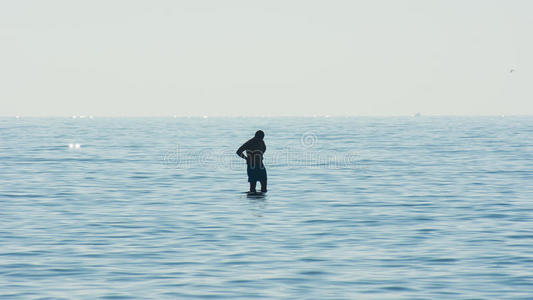 人在水的包围下沉思，一个人在海中的剪影