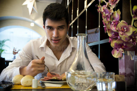 英俊的年轻人在优雅的餐厅吃午饭