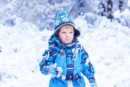 可爱的蹒跚学步的小男孩在冬天玩雪