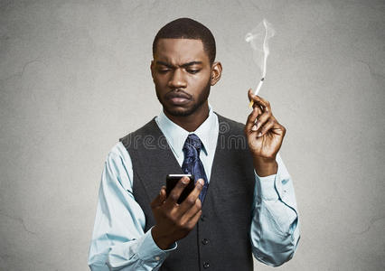 商人在智能手机上读短信,抽烟照片