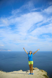 美丽的女孩沿着山海岸旅行