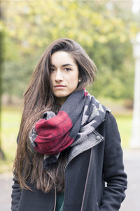公园里戴围巾的漂亮年轻女人。