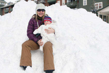 女人和婴儿坐在雪堆上