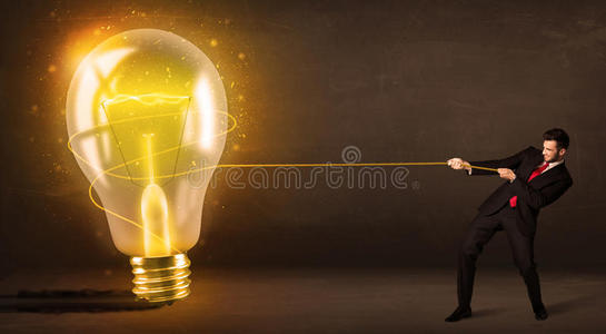 一个商人拉着一个发光的大灯泡