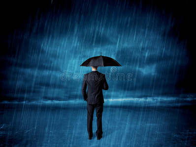 雨中撑伞的商人照片