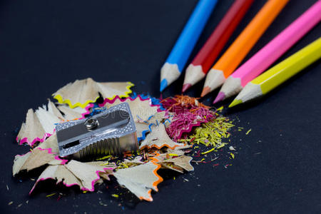 削尖的彩色铅笔从角落，金属铅笔刀和彩色铅笔刨花黑色