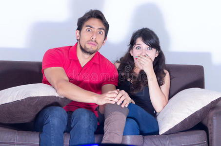 年轻漂亮的夫妇在家看电影