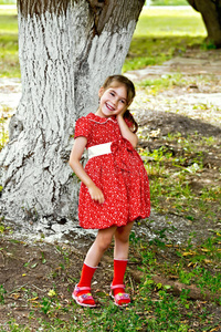 公园树下穿红裙子的女孩