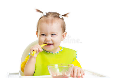 宝宝吃饭时用勺子坐在桌旁