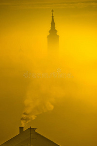 雾中的金色日出教堂塔