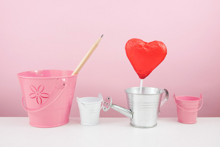 小银喷壶与小粉红桶红色挫败的心形巧克力棒