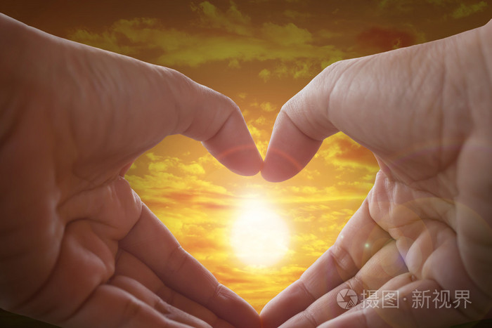 手作心形状与太阳光和天空背景