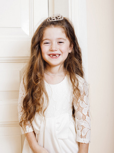 可爱的小女孩在家里，打开门衣着穿白色连衣裙，可爱牛奶童话牙齿