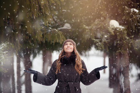 年轻漂亮的女人，在公园里享受降雪