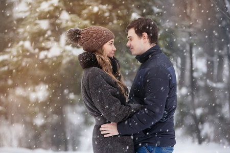 年轻的夫妇，在冬季的森林里的爱