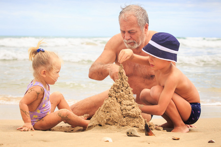 爷爷和儿童建设沙子城堡