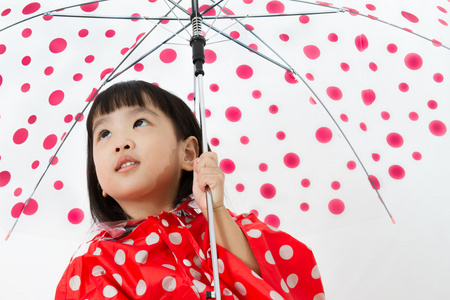 中国小女孩拿着雨伞和雨衣