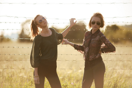 两个年轻的女朋友戴太阳眼镜很开心。生活方式