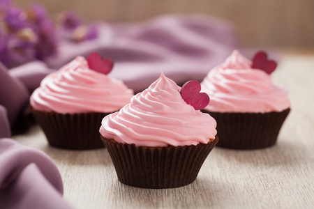 纸杯蛋糕传统生日庆祝甜点心老式背景上的粉色奶油和红用心照片
