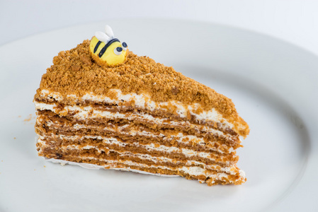 美味的蜂蜜蛋糕在盘子上与装饰蜜蜂浅D of