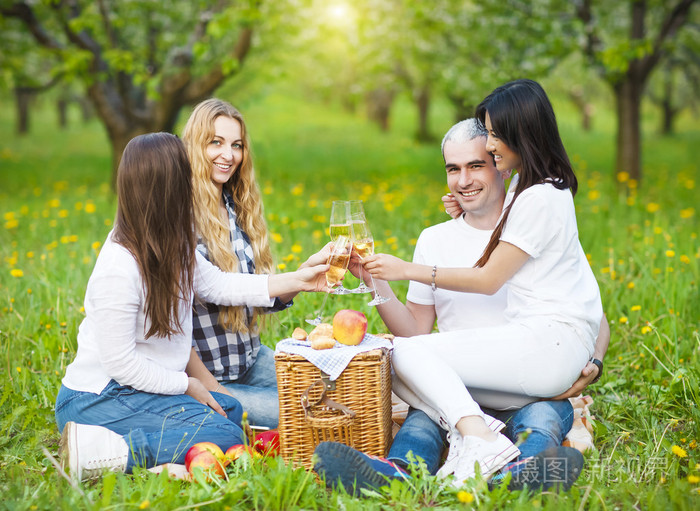 快乐的朋友在花园里的野餐喝香槟照片-正版商用图片1lsio5-摄图新视界