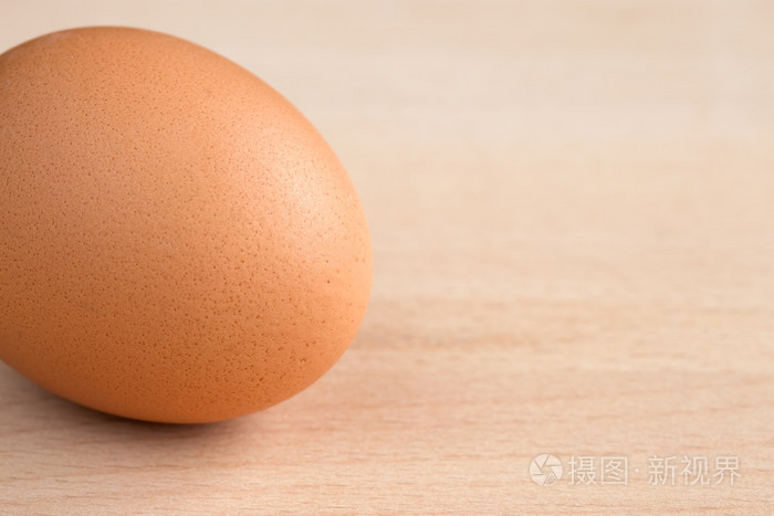木制切菜板上的单个棕色鸡蛋