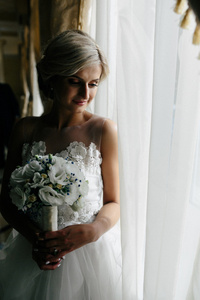 美丽的新娘穿婚纱的样子，由窗口